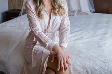 Gelin yatağın yanında piignoir giymiş.