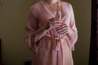 Peignoir 'deki kadın elinde bir kadeh şampanya tutuyor.