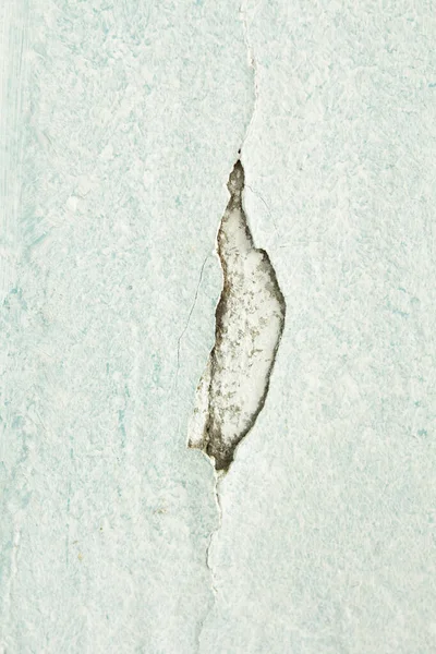 cracked white wall with fallen white paint crack