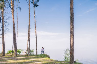 Birbirine aşık çiftler ormanın uçurumunda durur.