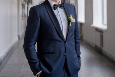 Damat eski bir binanın koridorunda duruyor.