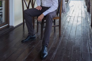 Adam verandada takım elbise giyer.