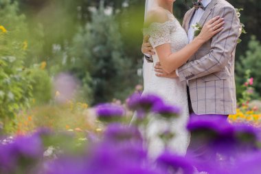 Gelin ve damat çiçeklerle parkta