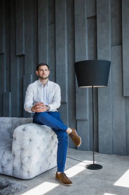 Beyaz gömlekli ve mavi pantolonlu adam.