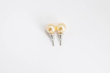 Beyaz arkaplanda inci küpeler