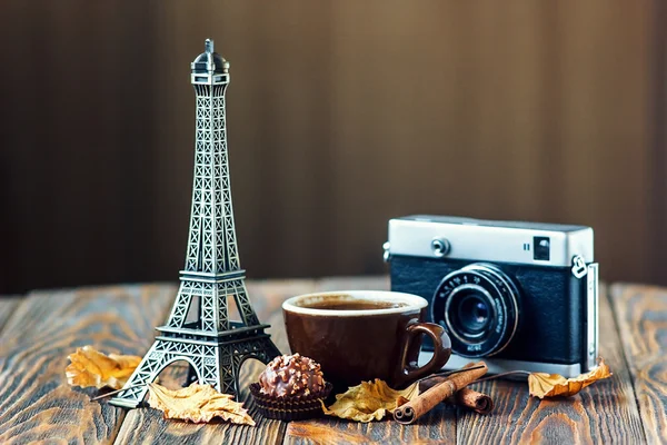Love Autumn Paris ! appareil photo vintage Tour Eiffel tasse à café chocolat automne feuilles cannelle bâtons sur table en bois Saint-Valentin concept Nostalgique vacances carte de fond avec place pour votre texte — Photo