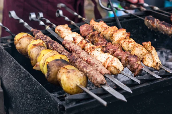 Grilling marinated shashlik preparing on a barbecue grill over charcoal.  Shashlik is a form of Shish kebab popular in Eastern Europe. Shashlyk (meaning  skewered meat) was originally made of lamb. Stock Photo