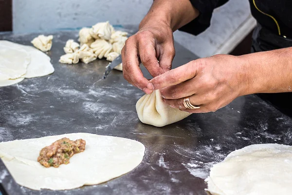 Cocina Georgiana Nacional Fondo de metal Khinkali Cook prepara cocina khinkali Vista superior plato de masa de carne cruda sin cocer Cabina de comida callejera venta de especialidad china Dumplings al vapor Proceso de cocción — Foto de Stock