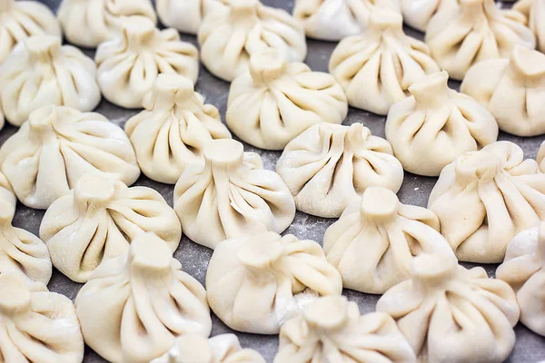 Nationale georgische Küche khinkali Metall Hintergrund Koch bereitet khinkali Küche von oben Ansicht rohes Fleisch Teiggericht ungekocht Street Food Stand Verkauf chinesischer Spezialität gedämpfte Knödel Prozess Kochen — Stockfoto