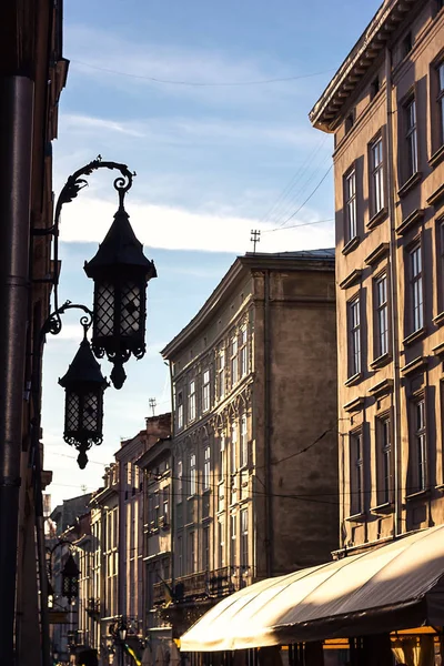 Mooie oude IJzeren lantaarn muur tegen blauwe hemel oude steen smalle picturale straat twilight oude stad in de buurt van centrale vierkante Lviv, Oekraïne. Karakteristiek verschijnsel middeleeuwse architectuur centraal-Europese Stockfoto