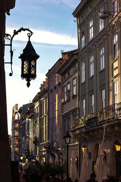 Hermosa antigua pared de linterna de hierro contra el cielo azul piedra vieja estrecha calle pictórica crepúsculo casco antiguo cerca de la plaza central de Lviv, Ucrania. Fenómeno característico arquitectura medieval Europa Central Imágenes de stock libres de derechos