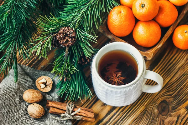 Navidad Año Nuevo composición invierno fiesta celebración concepto símbolo mandarinas clementina nueces pino conos abeto ramas taza té rústico estilo viejo madera tablero selectivo enfoque festivo tarjeta de felicitación — Foto de Stock