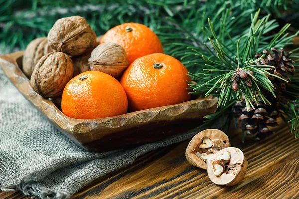 Yılbaşı yeni yıl kompozisyon kış tatil kutlama kavramı sembol mandalina mandalina clementine fındık çam kozalakları köknar dalları rustik tarzı eski ahşap tahta seçici odak Festival tebrik kartı