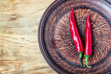 Biraz biber taze kırmızı olgun sıcak biber kopya alanı, Gine biber veya kuş biber, küçük kırmızı biber, ateşli biber eski ahşap tahta zemin üzerine koyu plaka üzerinde.