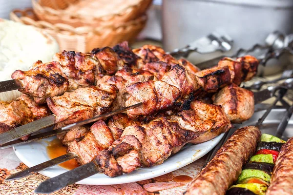 Grilling marinated shashlik preparing on a barbecue grill over charcoal.  Shashlik is a form of Shish kebab popular in Eastern Europe. Shashlyk (meaning  skewered meat) was originally made of lamb. Stock Photo