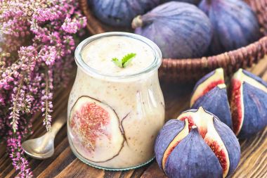 Güzel sağlıklı meze incir meyve güler yüzlü veya taze incir, üstten görünüm ile cam kavanoza muzlu süt. Doğal detoks. Sıvı dondurma. Ahşap zemin, seçici odak üzerine yoğurt kokteyl tatlı.