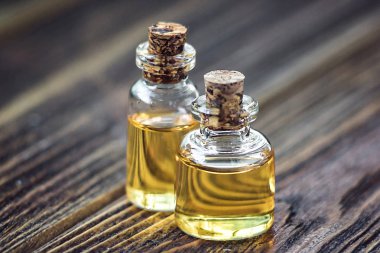 Saf Organik aroma esans ahşap arka plan güzellik bakımı üzerinde izole cam şişede. Kokulu yağ spa konsept sağlık ayarı. Seçici odak makro Önden Görünüm yatay. Metin için yer.