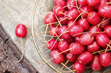 Olgun sonbahar zeytin meyveleri iğde Umbellata ahşap tahta üzerinde. İğde multiflora, Japon iğde, kiraz iğde, goumi, gumi, natsugumi, yarı evergreen sonbahar-zeytin çalı sığ odak.