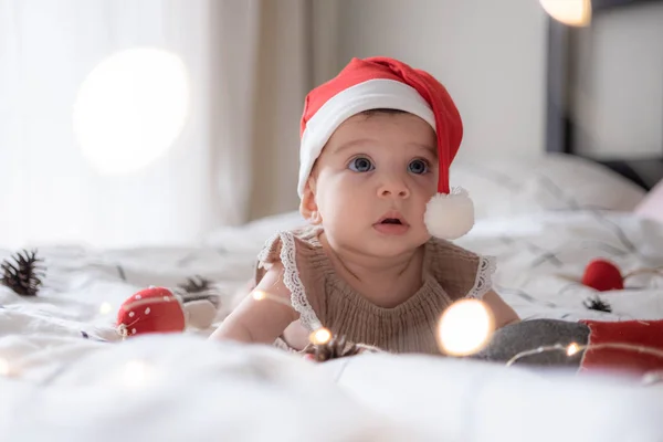 Petit bébé fille mignonne portreit en rouge Noël santa chapeau avec des lumières — Photo