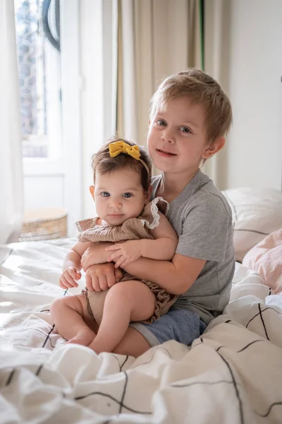 Klein baby meisje zitten samen met haar peuter broer — Stockfoto