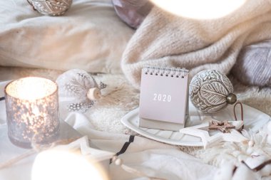 Yeni Yıl 2020 Takvimi. Kırsal sunucuda ışıkları olan tahta yıldız oyuncakları ve topları olan takvim.