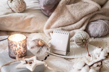 Yeni Yıl 2020 Takvimi. Kırsal sunucuda ışıkları olan tahta yıldız oyuncakları ve topları olan takvim.