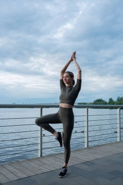 Genç bir kadın su arka planında egzersiz yapıyor. Sağlıklı yaşam