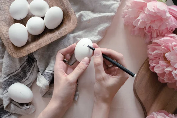 hands drawing geometric monochrome pattern on easter eggs. easter holiday concept