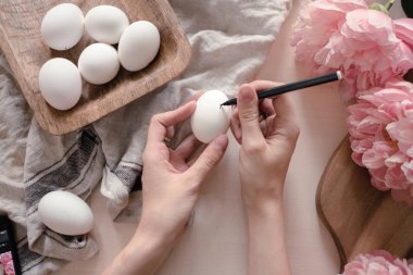 Paskalya yumurtalarına geometrik monokrom desenleri çizen eller. Paskalya tatili konsepti