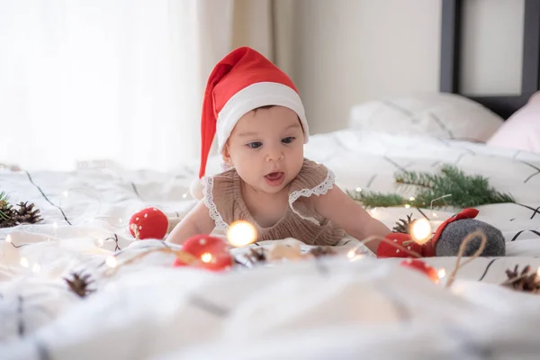 Kis aranyos kislány portreit piros karácsonyi Mikulás kalap fények — Stock Fotó