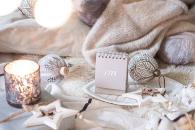 Yeni Yıl 2020 Takvimi. Kırsal sunucuda ışıkları olan tahta yıldız oyuncakları ve topları olan takvim.