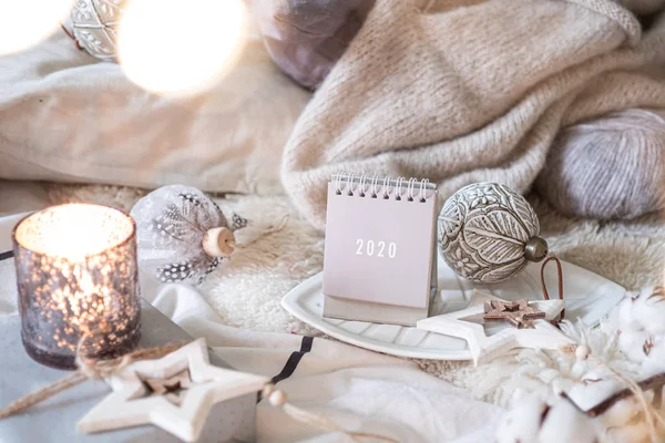 Yeni Yıl 2020 Takvimi. Kırsal sunucuda ışıkları olan tahta yıldız oyuncakları ve topları olan takvim.