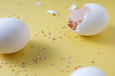 Sarı arka planda Paskalya yumurtaları ve renkli hamur işleri.