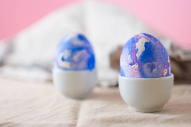 İki paskalya yumurtası suluboya akvaryumla süslenmiş klasik mavi renk, pembe arka planda minimalizm tarzı. Fotokopi alanı olan Paskalya tatili dekorasyonları