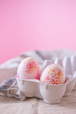 İki paskalya yumurtası suluboya akvaryumla süslenmiş, sade pembe arka planda minimalizm tarzı. Fotokopi alanı olan Paskalya tatili dekorasyonları