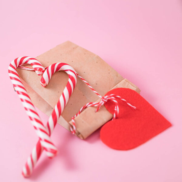 Концепция Святого Валентина. Подарок и конфеты трость услышать на розовом фоне
