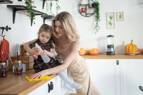 Jeune mère faisant des travaux ménagers à la cuisine avec sa fille tout-petit. Vie domestique — Photo