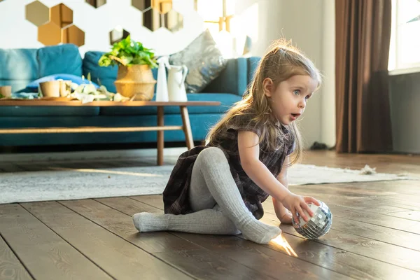 Маленькая милая девочка малыша играет с мячом в современном доме в скандинавском стиле интерьера — стоковое фото