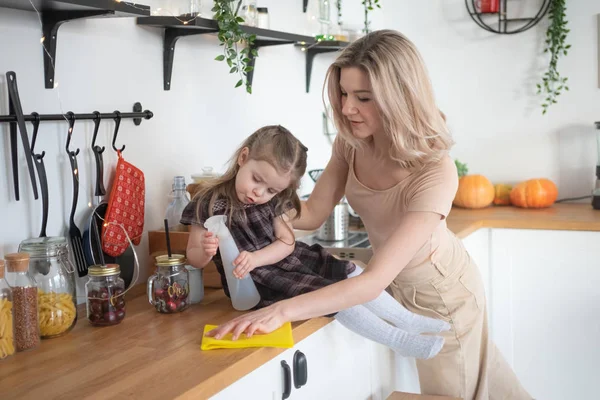 Jeune mère faisant des travaux ménagers à la cuisine avec sa fille tout-petit. Vie domestique — Photo