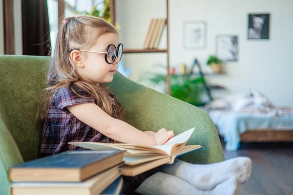 Kleines Mädchen mit Brille, das ein Buch liest. zurück zum Schulkonzept — Stockfoto