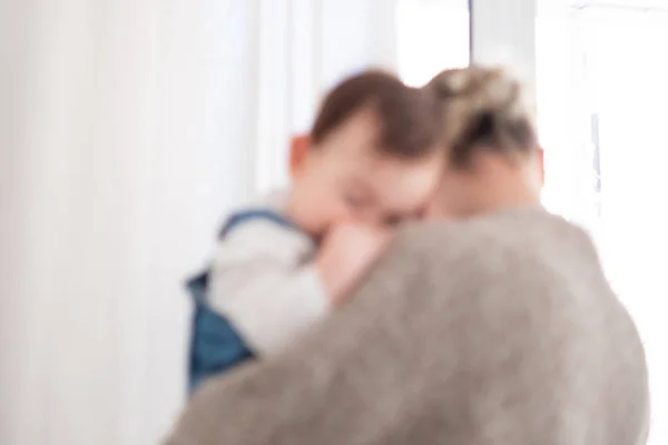 Oskärpa mamma hålla ett spädbarn bakgrund. Familjelivsstil — Stockfoto