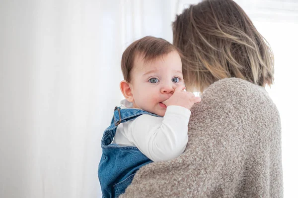 Mother holding little infant baby on white background. Lifestyle family concept. — Stock Photo, Image