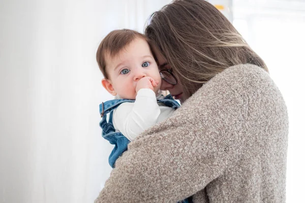 Mother holding little infant baby on white background. Lifestyle family concept. — Stock Photo, Image