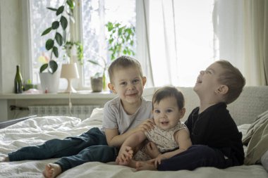  Bebekler ve kız kardeşler yatakta birlikte oturuyorlar. Yaşam tarzı aile kavramı