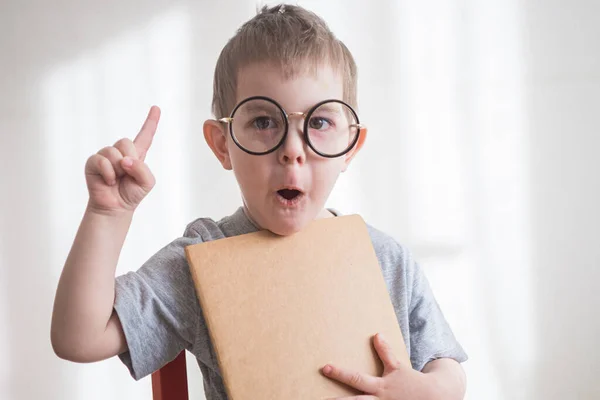 Kleine peuter met bril en hand omhoog met ideeënbord. Terug naar schoolconcept — Stockfoto