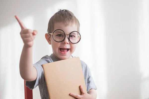 Kleine peuter met bril en hand omhoog met ideeënbord. Terug naar schoolconcept — Stockfoto