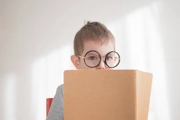 Gözlükle kitap okuyan tatlı çocuk. Zeki anaokulu öğrencisi. Okul konseptine dönelim. — Stok fotoğraf