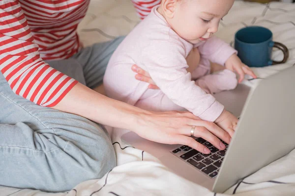 stock image Mother working on laptop at home together with infant baby. Distance work, education. work from home, working mother.