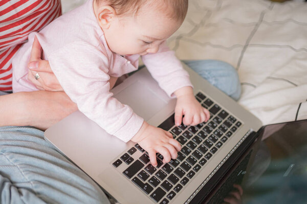 Мать работает на ноутбуке дома вместе с младенцем. Дистанционная работа, образование. работа из дома, работающая мать
.