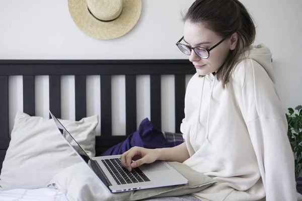 Woman making video call via laptop sitting on bed at home. Lifestyle concept. Social distance self quarantine isolation — Stock Photo, Image